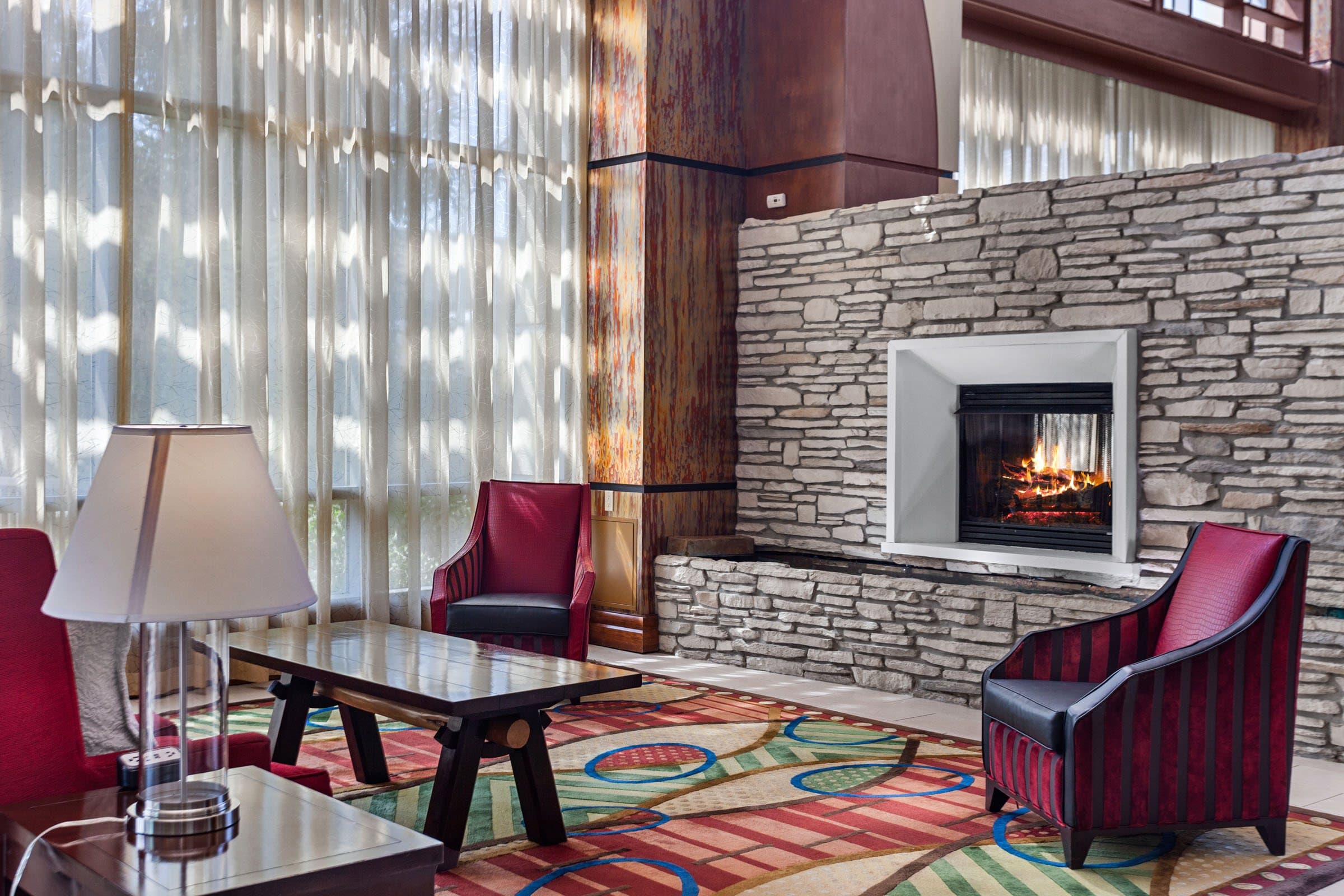 Wide interior of a lounge with a stone fireplace, staged for a video walkthrough