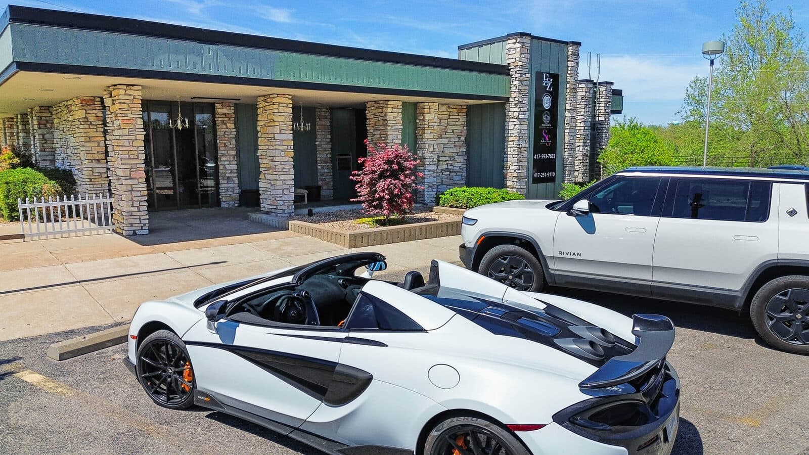 Exterior of an auto showroom with sports cars staged out front