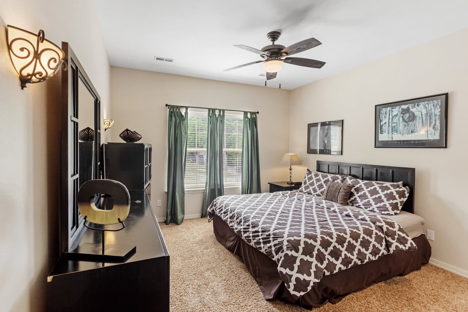 Bedroom with a king bed, a ceiling fan, and framed wall art