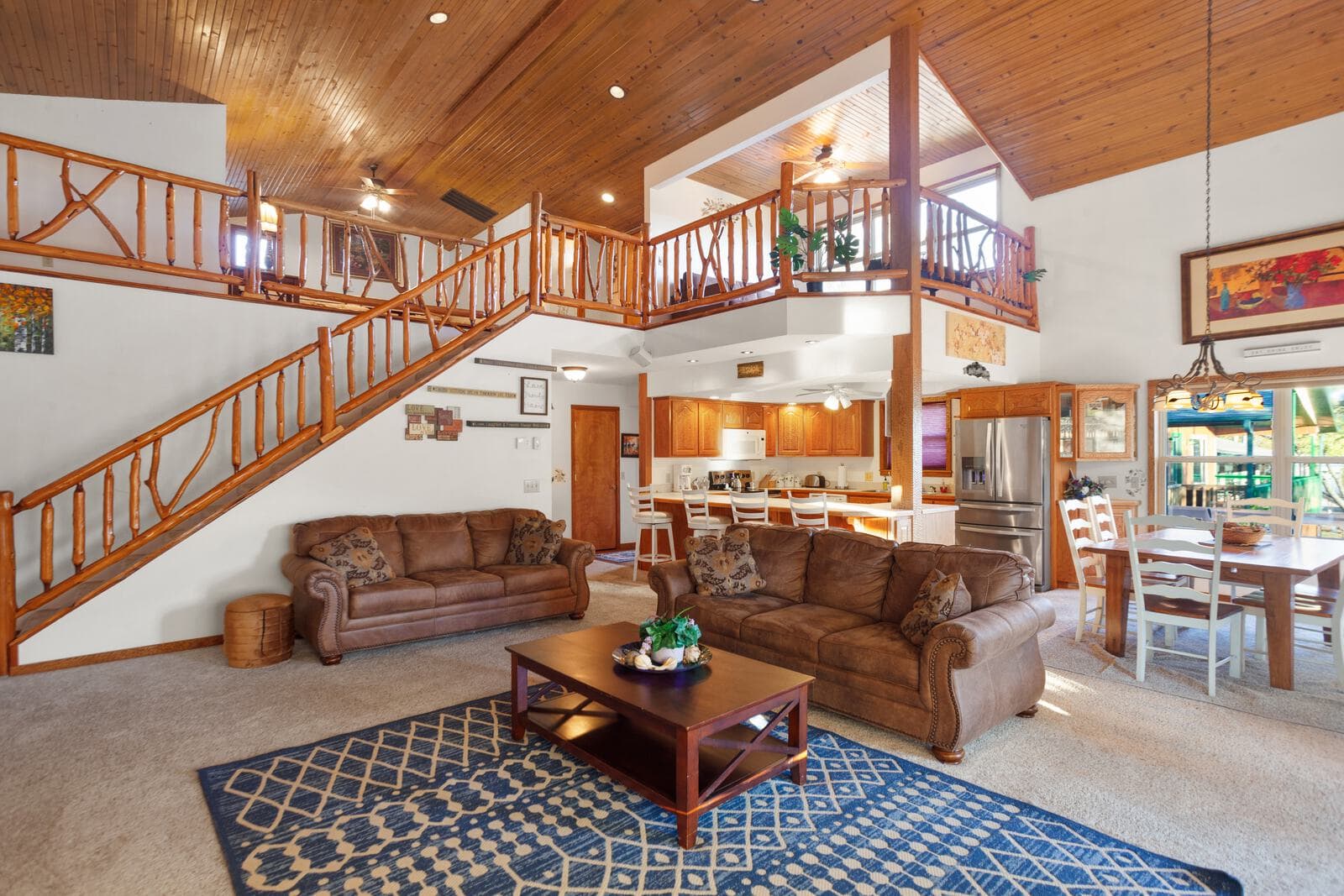 Warm cabin living room with wood beams and stone fireplace