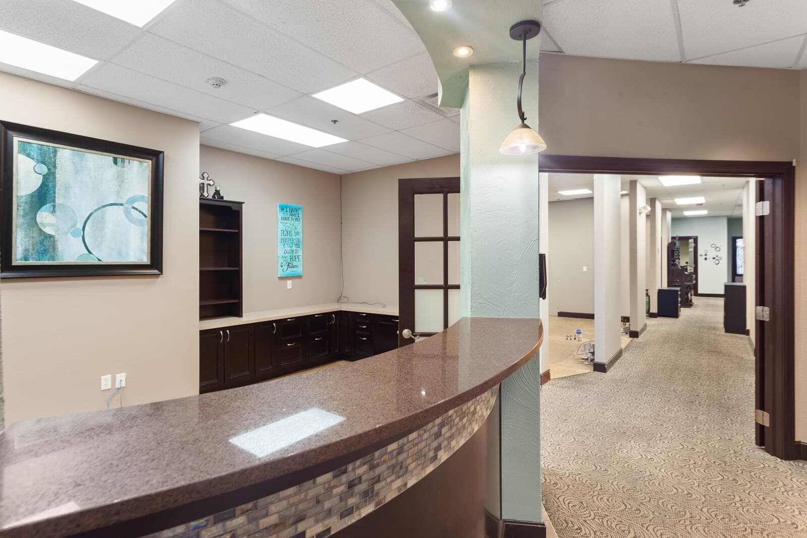 Evening exterior of a commercial building entrance with warm interior lighting