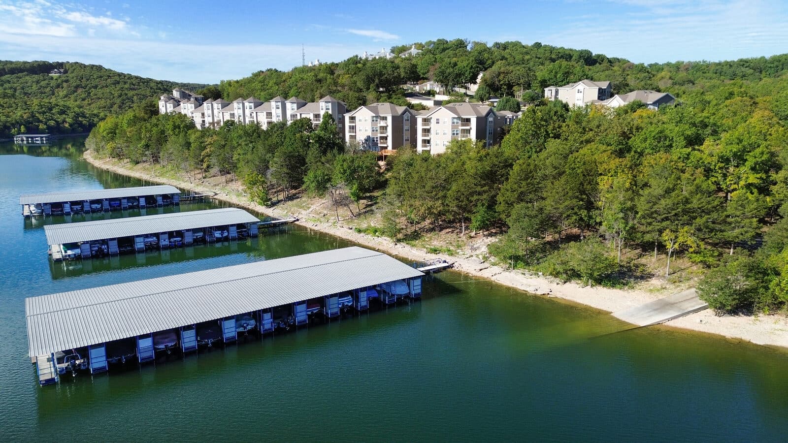 Aerial view of lakefront condos above rows of covered boat slips