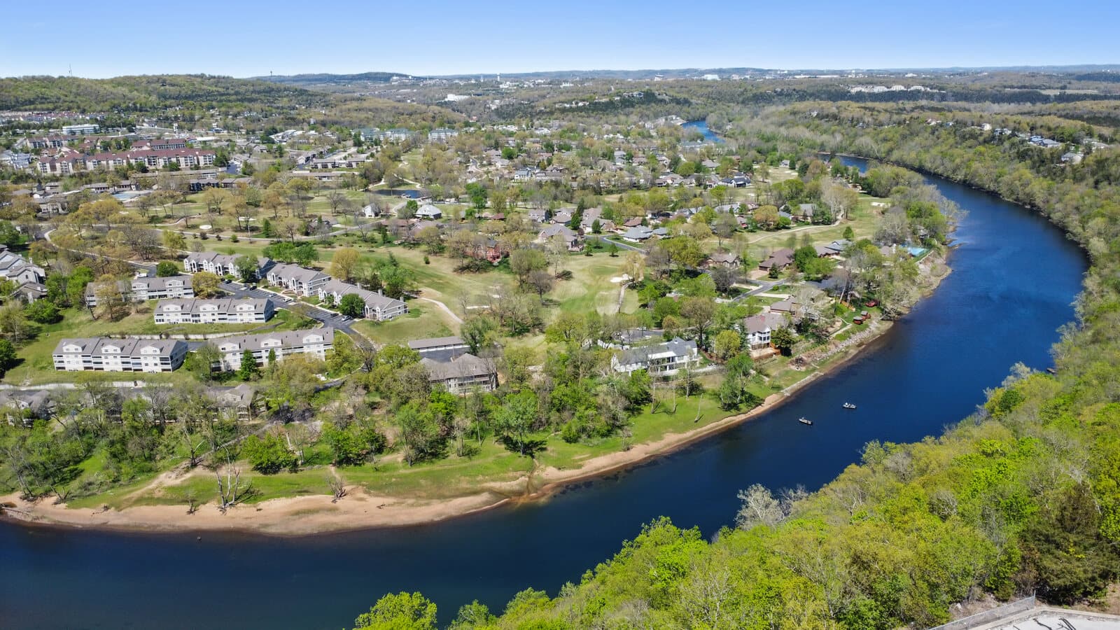 Aerial view of a riverfront neighborhood along a bend in the water in the Branson area